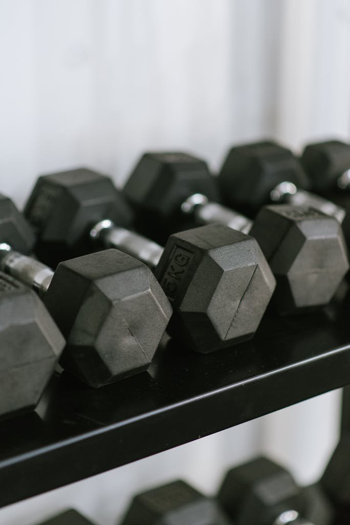 Close-up of hex dumbbells neatly arranged on a rack in a gym, perfect for fitness themes.